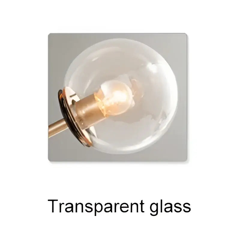 Clear spherical glass ball chandelier with brass-toned fixture and illuminated bulb by DecorBites glass for dining room lighting