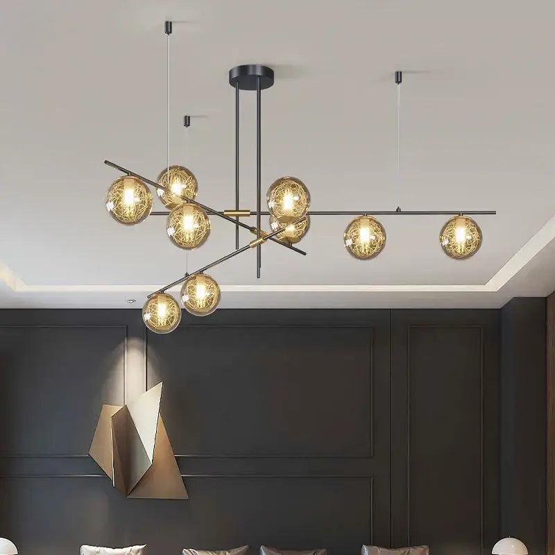 Modern black metal decorbites glass ball chandelier with spherical glass globes emitting warm golden glow for ceiling lighting