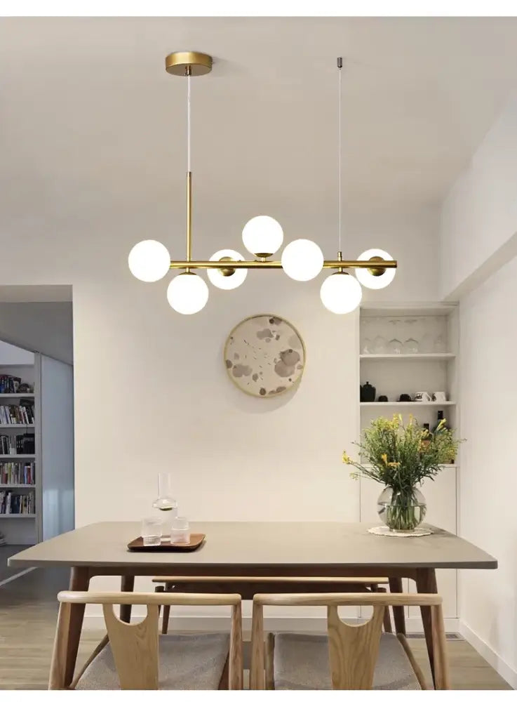 DecorBites™ glass ball chandelier with gold-toned metal and multiple spherical glass bulbs in a modern linear design