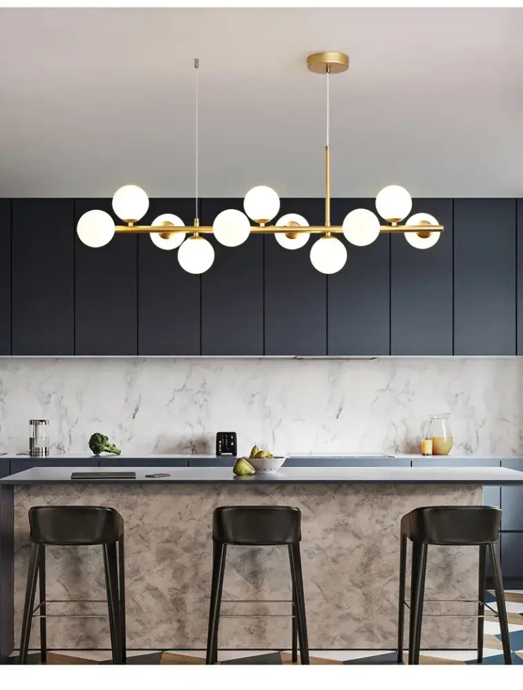 Modern gold-toned pendant light with multiple white glass ball bulbs in a linear design by DecorBites glass ball chandelier