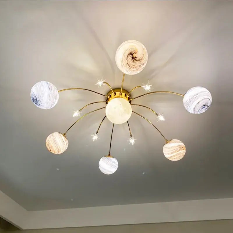 Gold-toned decorbites glass ball chandelier with six planet-inspired marbled globes for kids room and living room