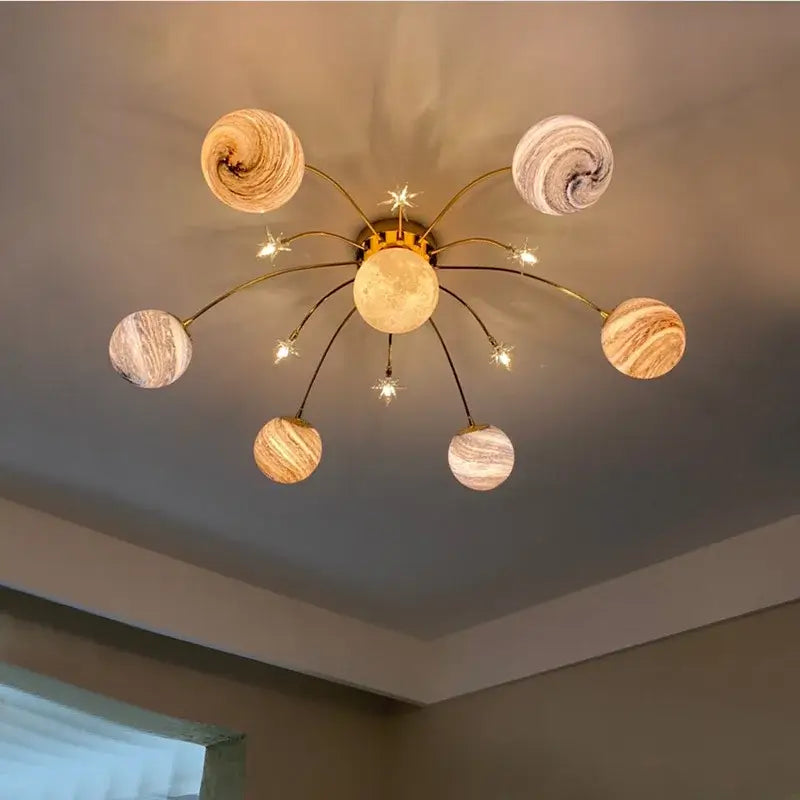 Golden decorbites glass ball chandelier with planet-inspired globe shades and starburst accents for kids room and living room