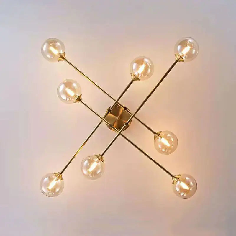 Gold-toned DecorBites glass ball chandelier wall sconce with eight exposed filament bulbs in starburst pattern