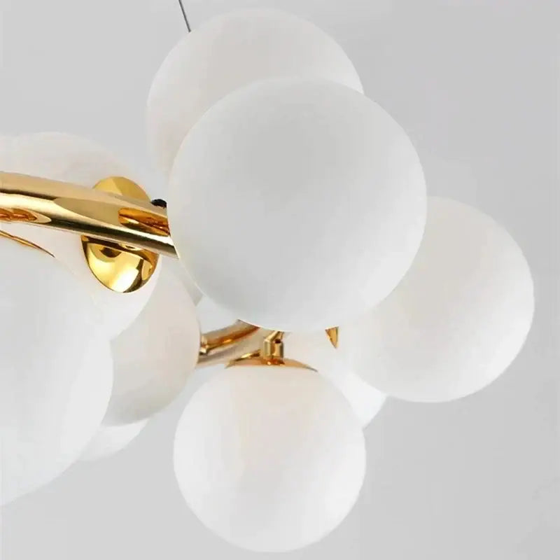 DecorBites glass ball chandelier with modern white frosted glass globes and polished gold-toned metal arms for living room