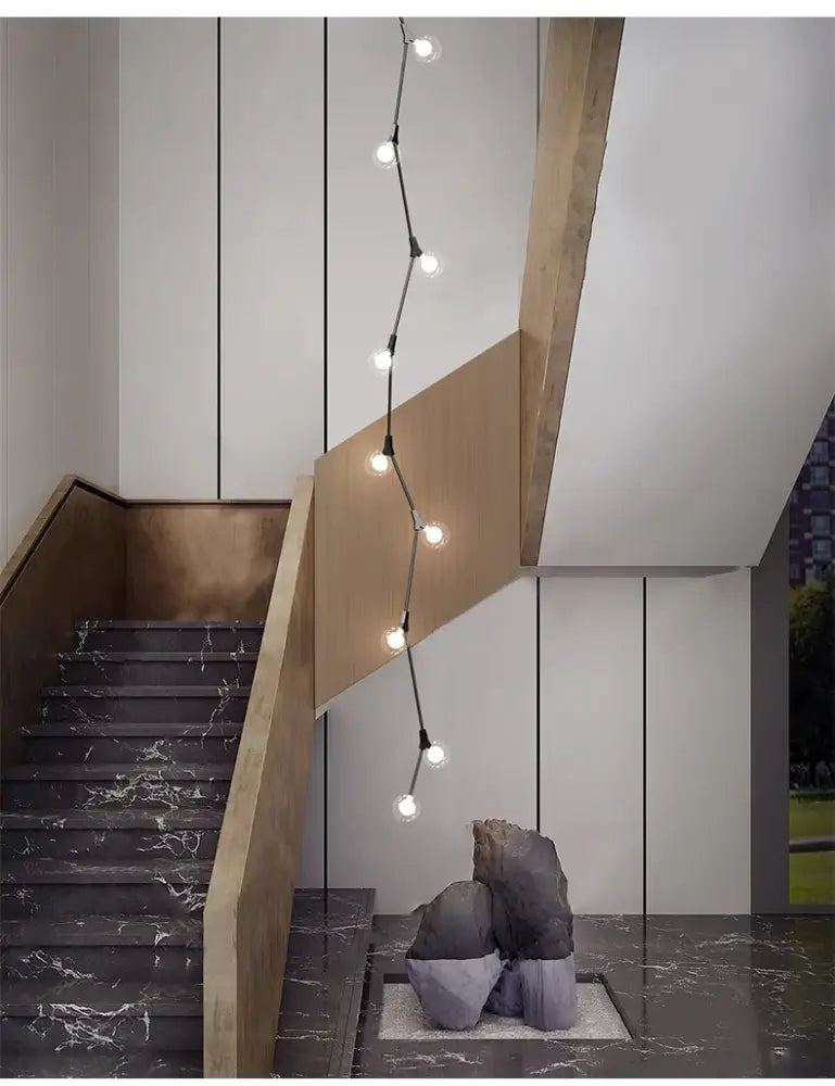 A sleek decorbites glass ball chandelier with black cord and spherical bulbs for villa hotel staircase decor