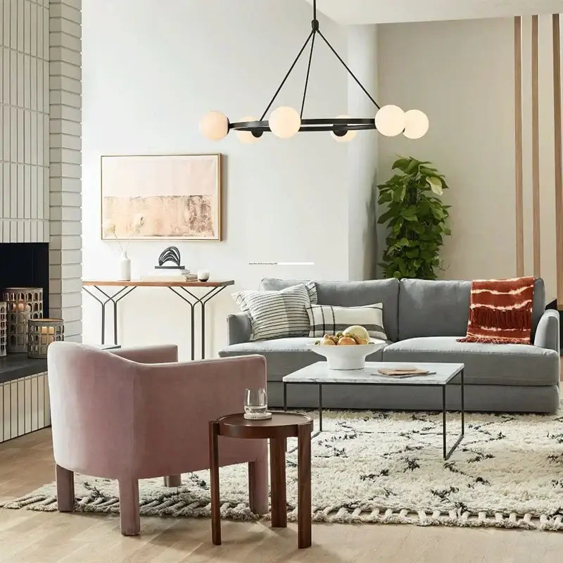 Gray sectional sofa with striped and plaid pillows beneath a modern nordic style decorbites glass ball chandelier pendant light
