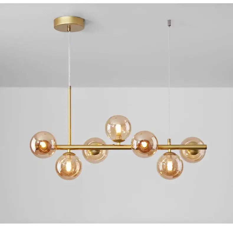 Decorbites™ glass ball chandelier lighting fixture with seven amber glass globes and gold-toned brass bar suspension