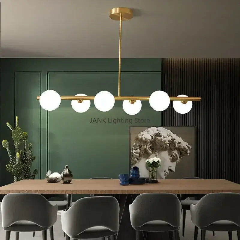 Gold-toned modern decorbites glass ball chandelier with six frosted glass globes in a linear design for home decor