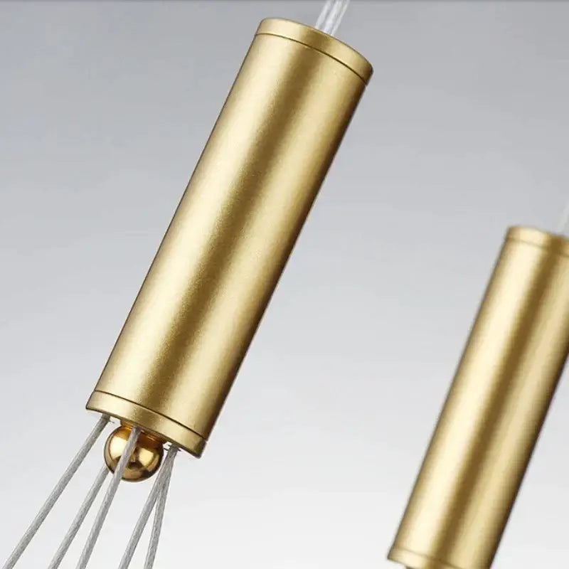 Gold-colored cylindrical pendant with polished metallic finish and spherical accent from decorbites glass ball chandelier