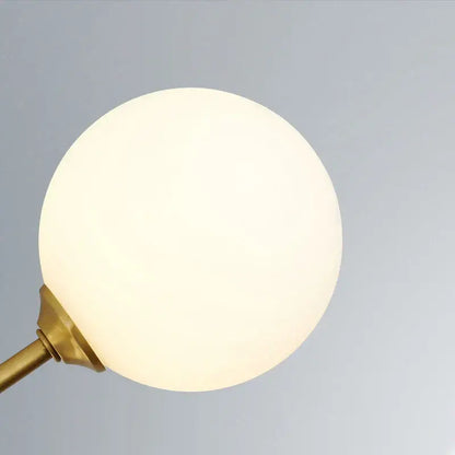 A warm frosted glass globe lamp with brass finish metal base in decorbites glass brass chandelier pendant light