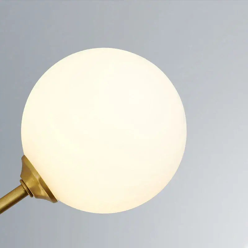A warm frosted glass globe lamp with brass finish metal base in decorbites glass brass chandelier pendant light