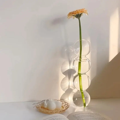 DecorBites™ glass bubble hydroponic vase with stacked spherical segments holds a single orange daisy for weddings and home
