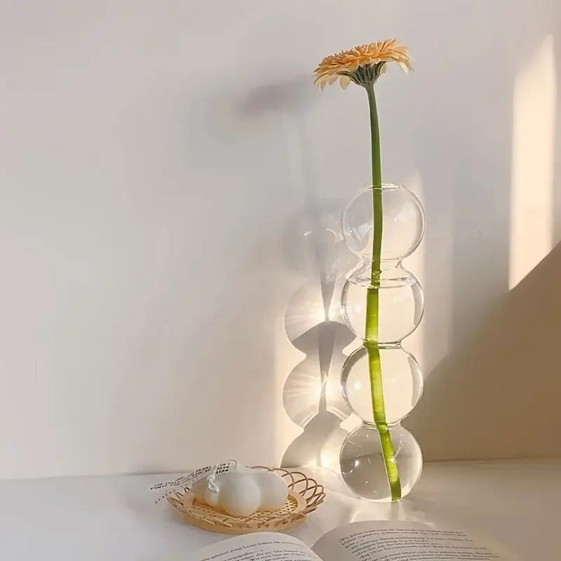 DecorBites™ glass bubble hydroponic vase with stacked spherical segments holds a single orange daisy for weddings and home