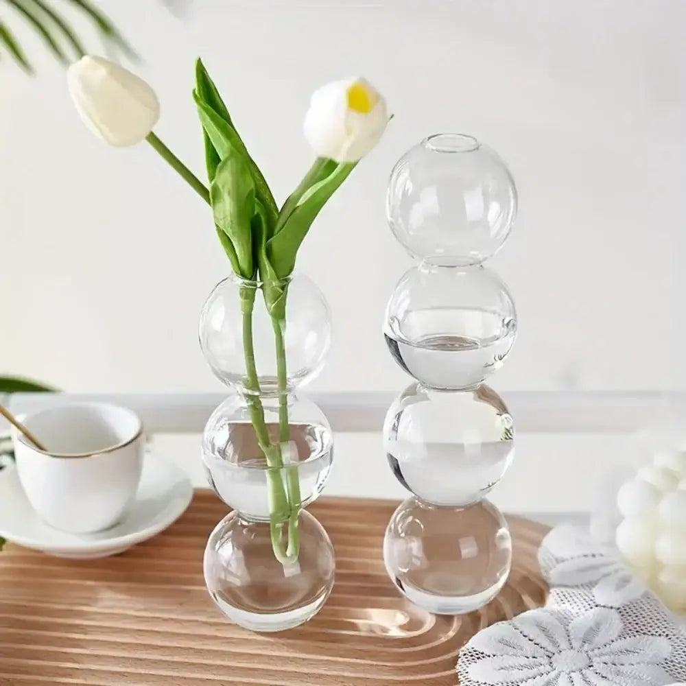 Clear glass spherical vase with stacked transparent orbs holding white tulips in decorbites glass bubble hydroponic design