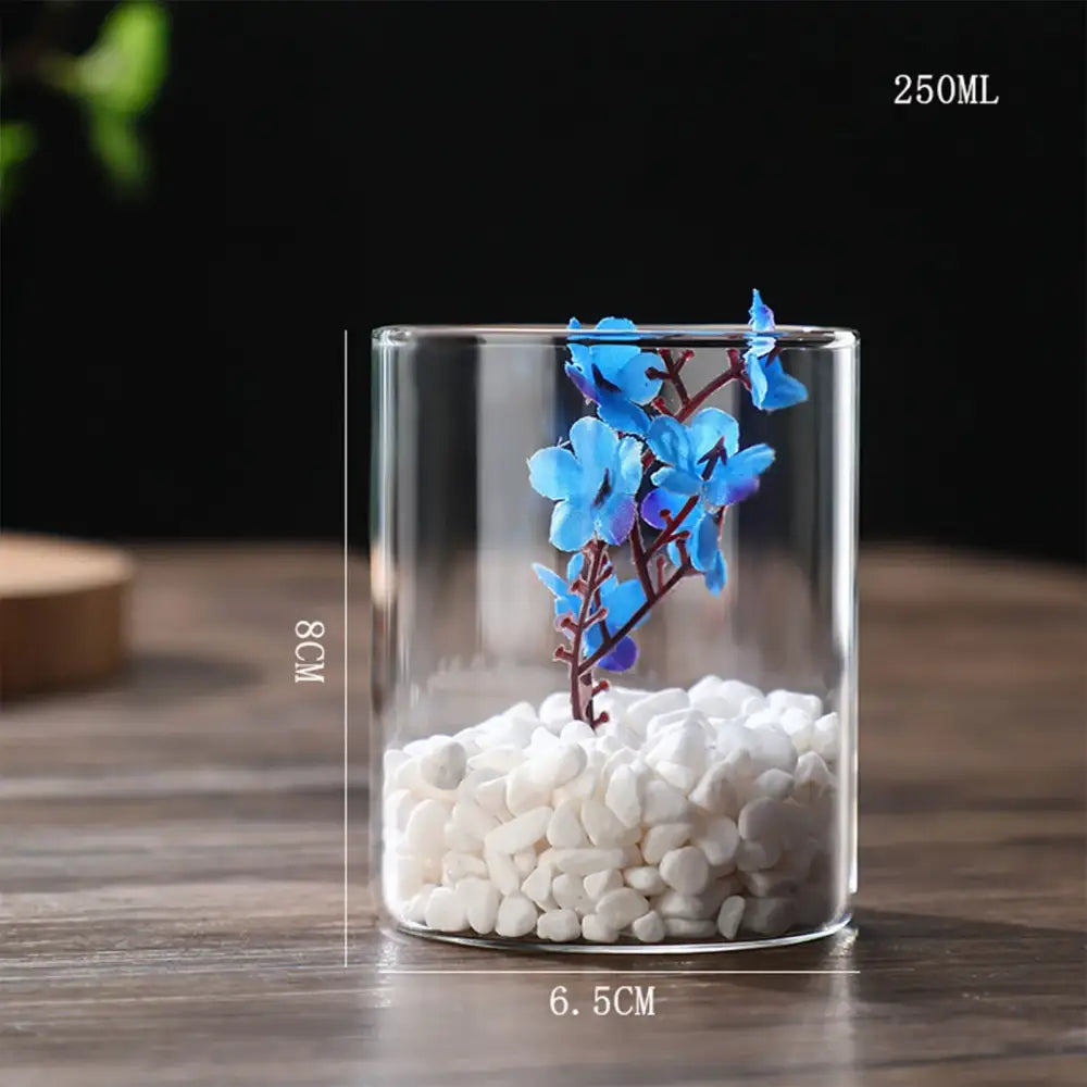 DecorBites glass vase with white pebbles and blue artificial flowers as a stylish planter vase for desktop decor