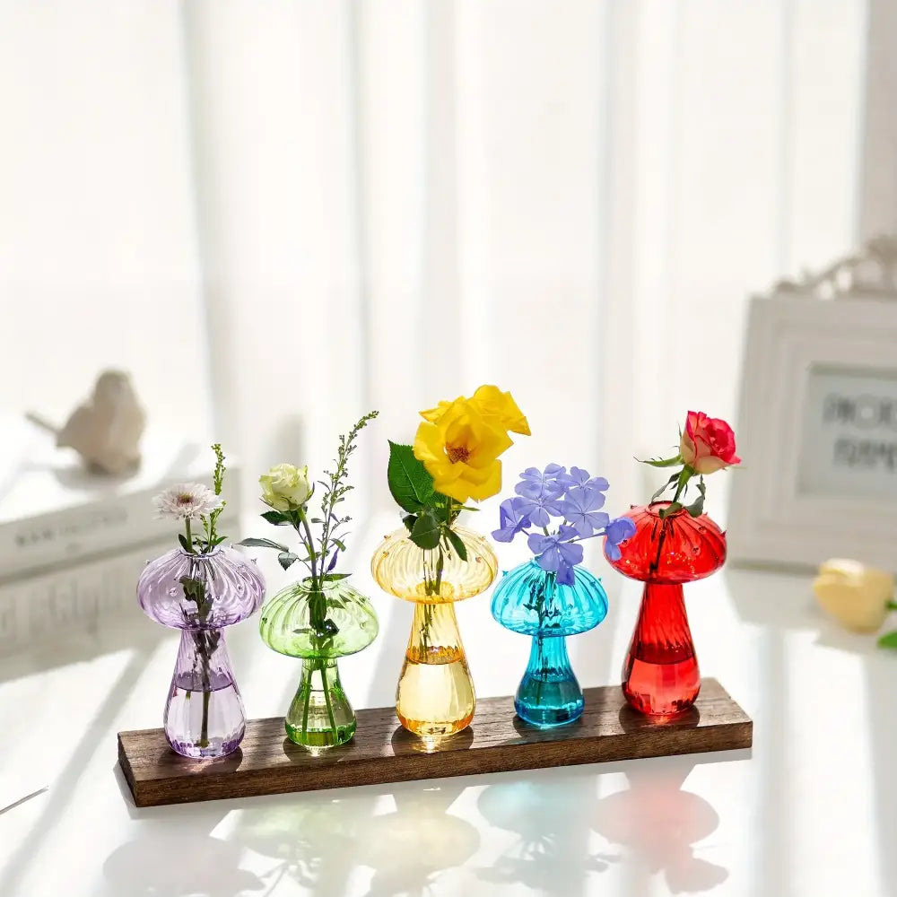 Set of five colorful decorbites™ glass mushroom hydroponic planters in purple green yellow blue and red holding flowers