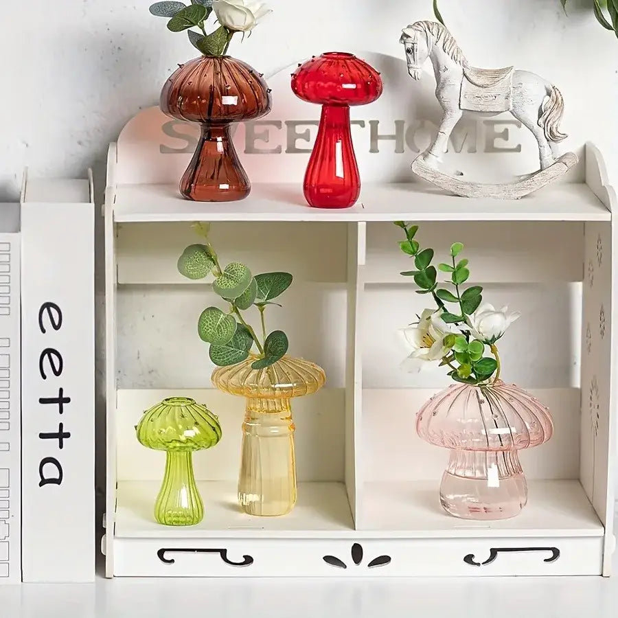 Set of four colorful glass mushroom hydroponic planters in red amber green and pink for home and garden decor