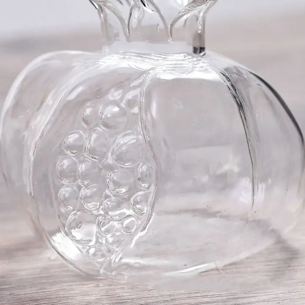 Clear glass pomegranate glass decanter with embossed seed details and molded crown top for home decor and glass vase use