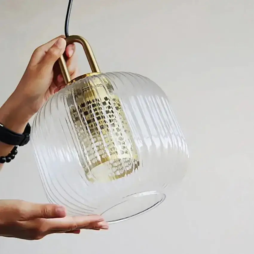 Clear ribbed glass stripe pendant light by Decorbites with brass finish and hanging cord for dining room lighting