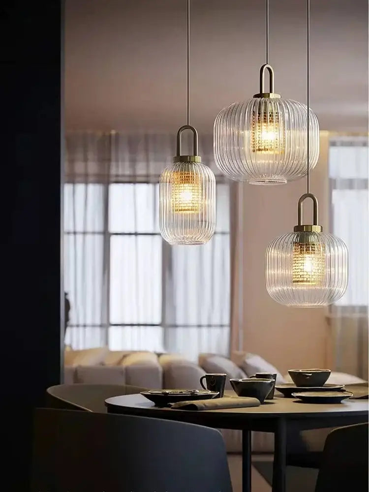 Three elegant decorbites glass stripe pendant lights with vertical ridges and brass fixtures for dining room use