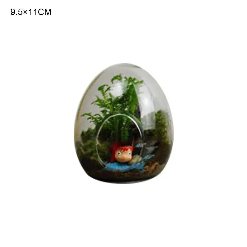 High quality glass egg-shaped terrarium with green plants and red accessory figurine by DecorBites™