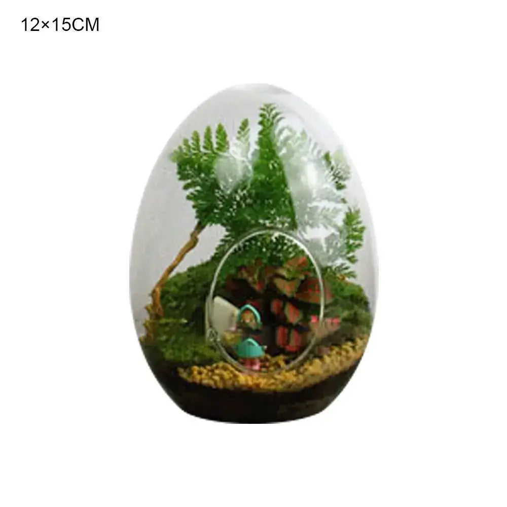 DecorBites™ high quality glass egg-shaped terrarium with miniature green ferns moss and a tiny figurine inside