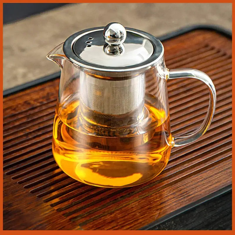 Clear glass tea jug set by decorbites with stainless steel lid handle and built-in filter holding golden tea