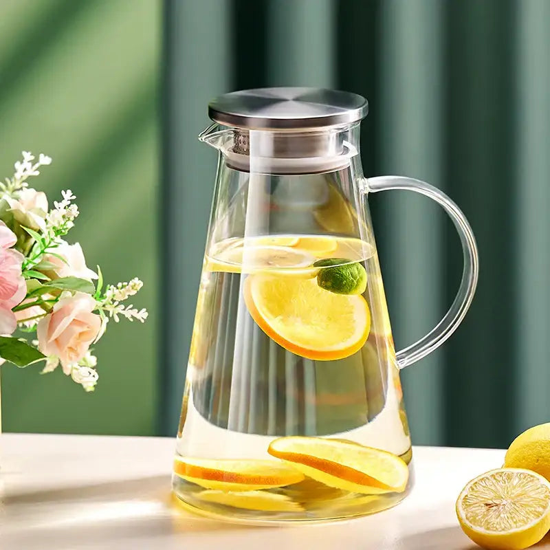 Clear glass tea jug with stainless steel lid and handle filled with lemon-infused water from decorbites water kettle set