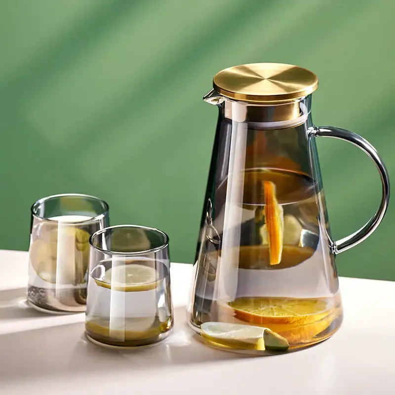 DecorBites glass tea jug with gold lid and handle filled with lemon water in heat resistant water kettle set