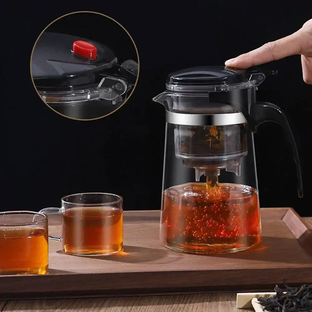 DecorBites glass tea kettle with infuser features clear glass body, black lid and handle, and silver metallic band