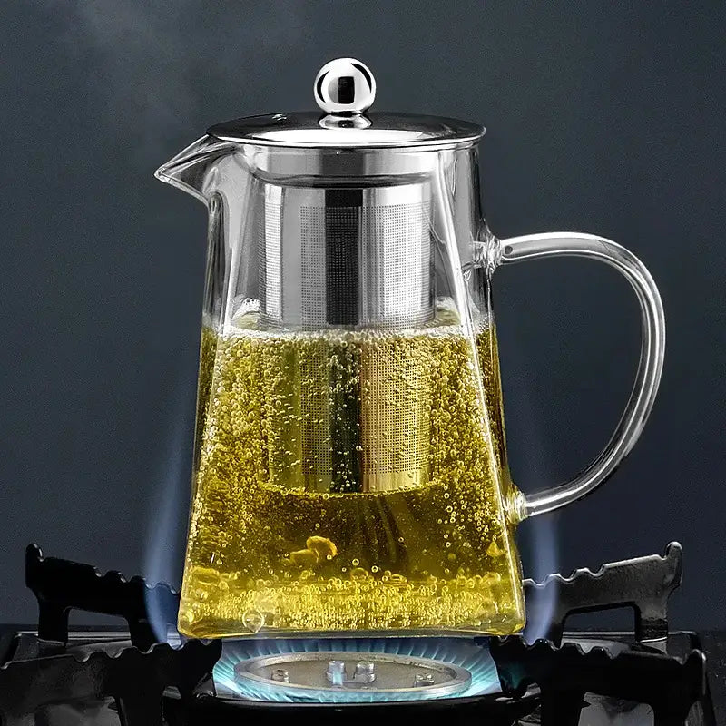 Clear glass tea pot with stainless steel lid and built-in filter filled with steaming golden tea decorbites glass tea pot