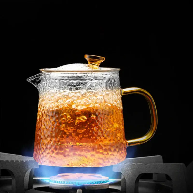 DecorBites glass tea pot set with clear hammered glass and gold-toned handle filled with amber tea for kung fu brewing