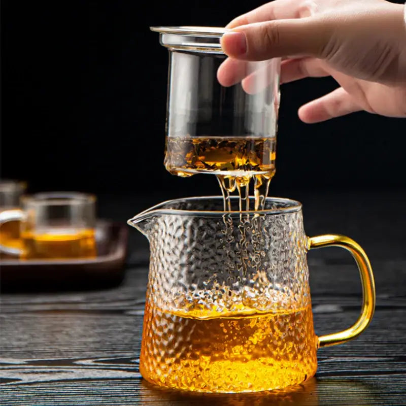 Decorbites™ glass tea pot set with textured glass and golden handle filled with amber tea for kung fu brewing