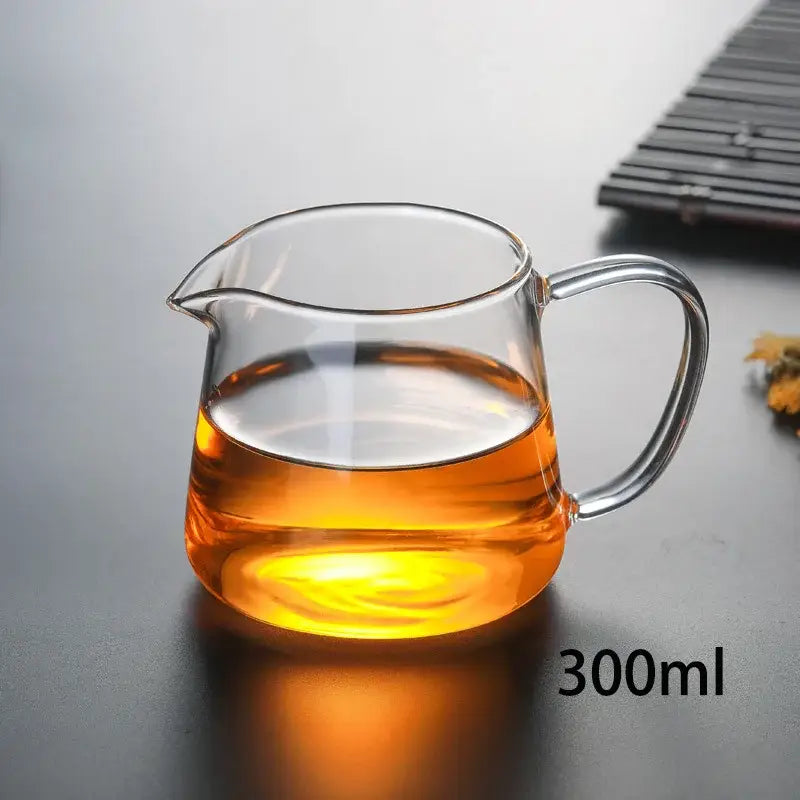 DecorBites glass tea pot set with amber tea in a clear heat-resistant glass pot with curved handle and spout