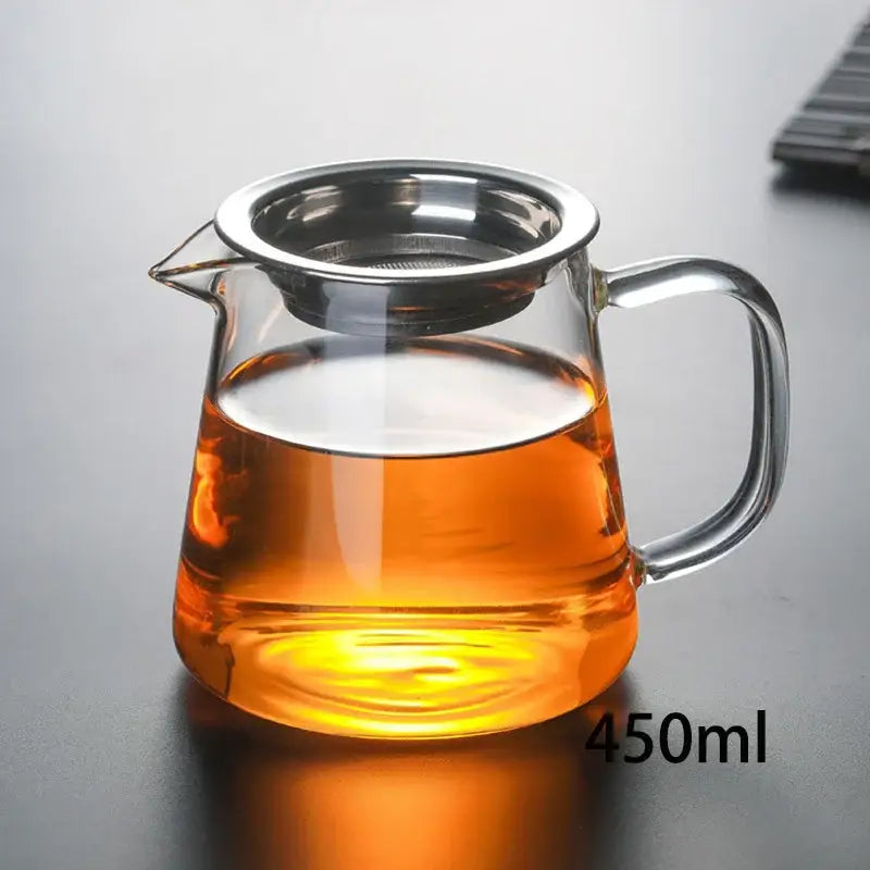 Clear glass tea pot set with stainless steel infuser filled with amber tea for puer tea brewing by decorbites
