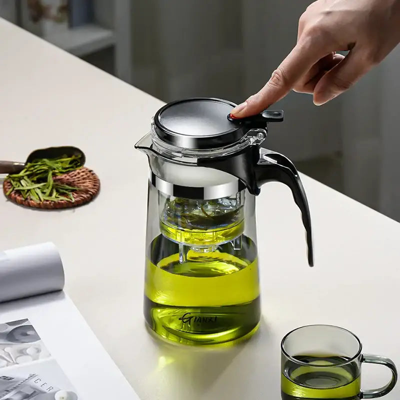 DecorBites glass tea pot with infuser features clear glass, black handle, stainless steel lid, and internal strainer for steeping