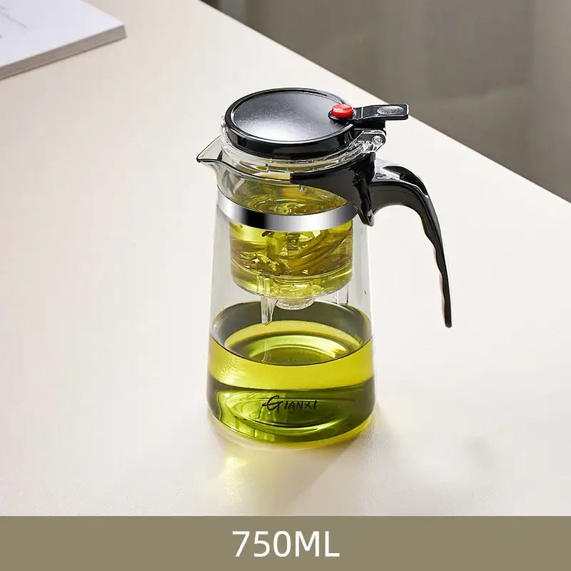 Decorbites glass tea pot with infuser features clear glass, black lid, handle, and silver rim brewing yellow-green tea