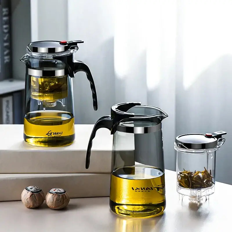 Clear glass tea pot with black handle and silver rim featuring built-in strainer for steeping loose-leaf tea by DecorBites glass tea