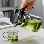 Clear glass tea pot with black lid and handle and silver metallic band from DecorBites glass tea set with infuser