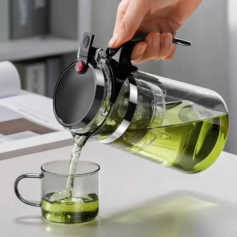 Clear glass tea pot with black lid and handle and silver metallic band from DecorBites glass tea set with infuser