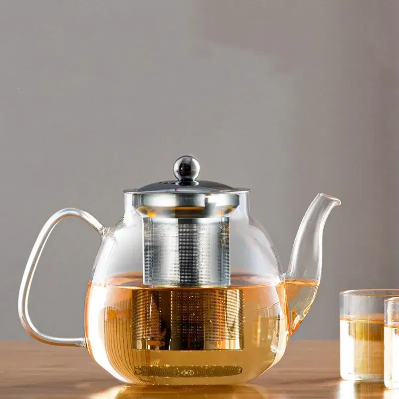 DecorBites™ glass tea pot with stainless steel lid and built-in filter filled with amber tea for steeping puer and coffee