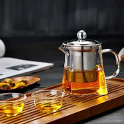 Decorbites glass tea pot with stainless steel infuser and built-in filter filled with amber tea in clear glass