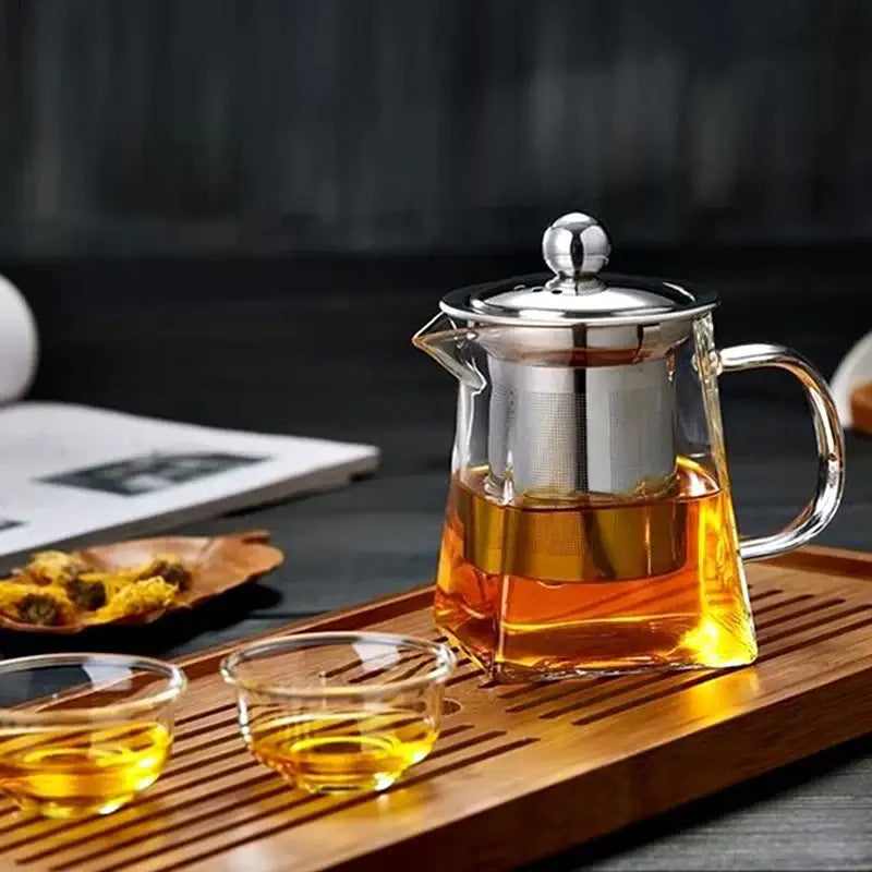 Decorbites glass tea pot with stainless steel infuser and built-in filter filled with amber tea in clear glass