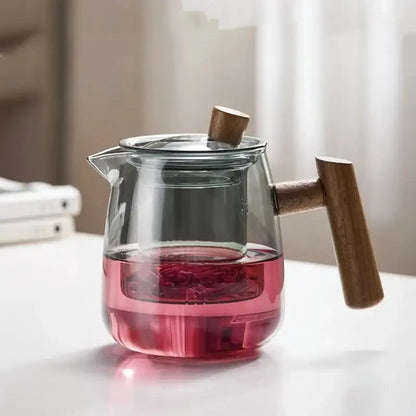 Clear glass decorbites glass tea pot with wooden handle and lid knob containing pink herbal tea for kung fu tea use