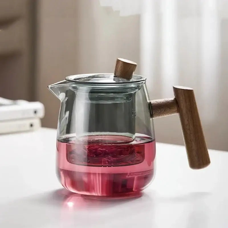 Clear glass decorbites glass tea pot with wooden handle and lid knob containing pink herbal tea for kung fu tea use