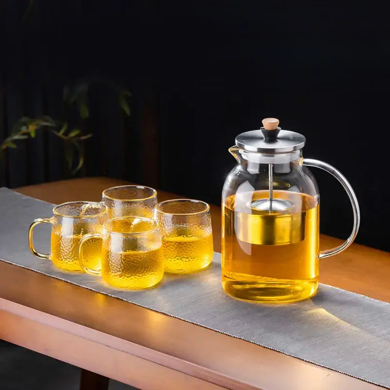 Clear glass teapot with stainless steel lid and handle filled with golden tea from decorbites glass tea set
