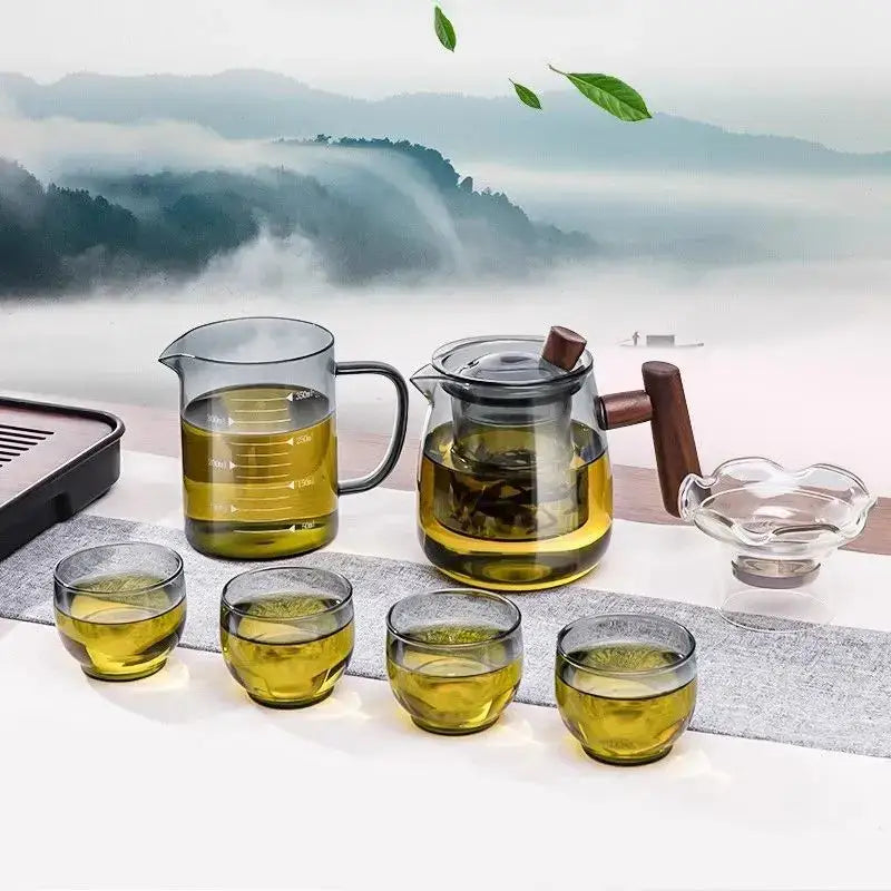 DecorBites glass tea set with clear glass teapot filled with golden tea and solid wood handle and lid