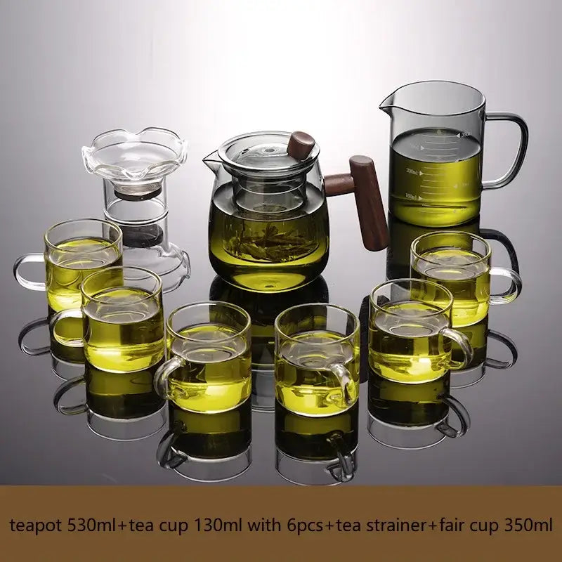 Clear glass tea set with solid wood handle and lid filled with green tea featuring tea water separation technology