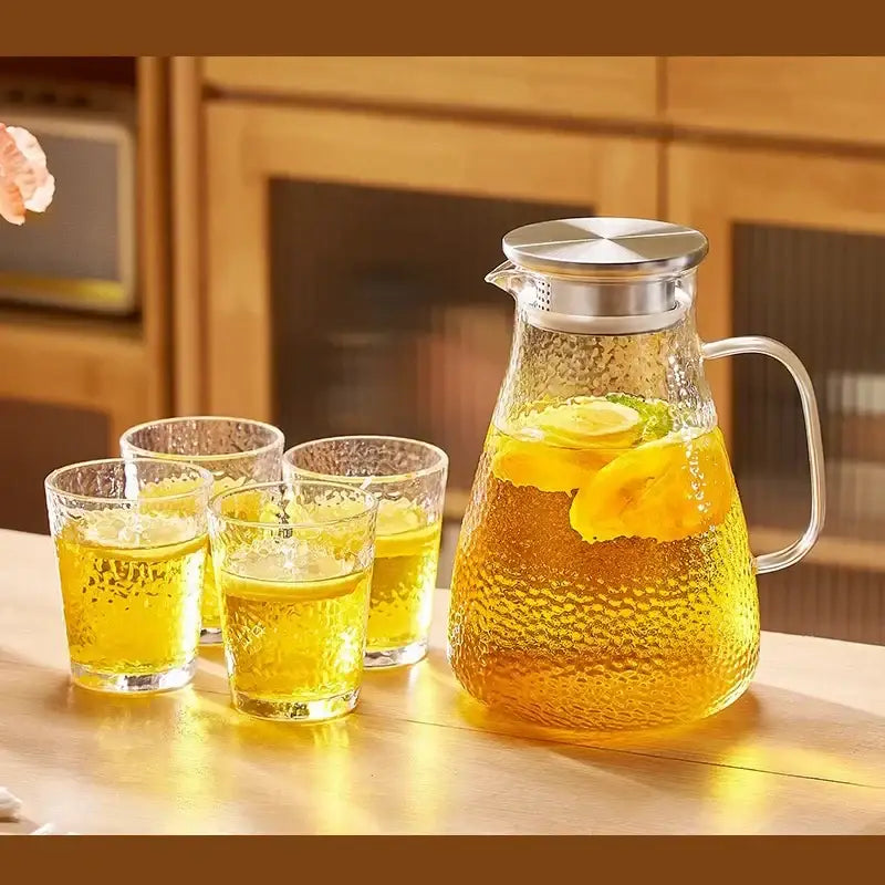 Clear textured glass pitcher filled with lemon tea in decorbites glass tea set with stainless steel lid and handle