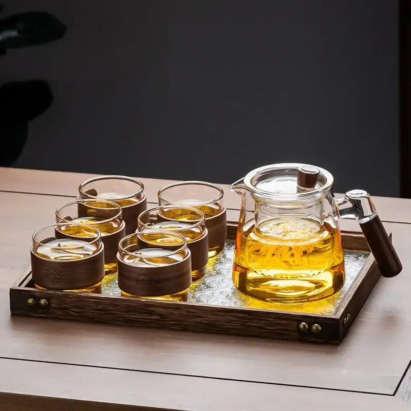 Clear glass tea set with wooden handle teapot and six glasses on a retro glass tray by decorbites